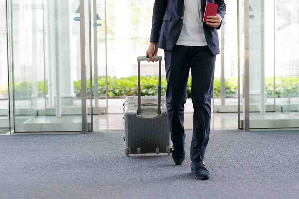 Mann mit Koffer am Flughafen